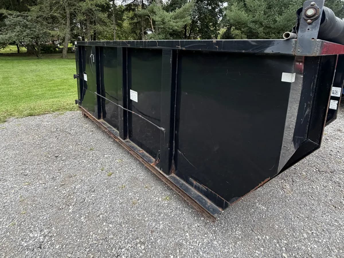 Moore's 14-yard black roll-off dumpster on a gravel lot